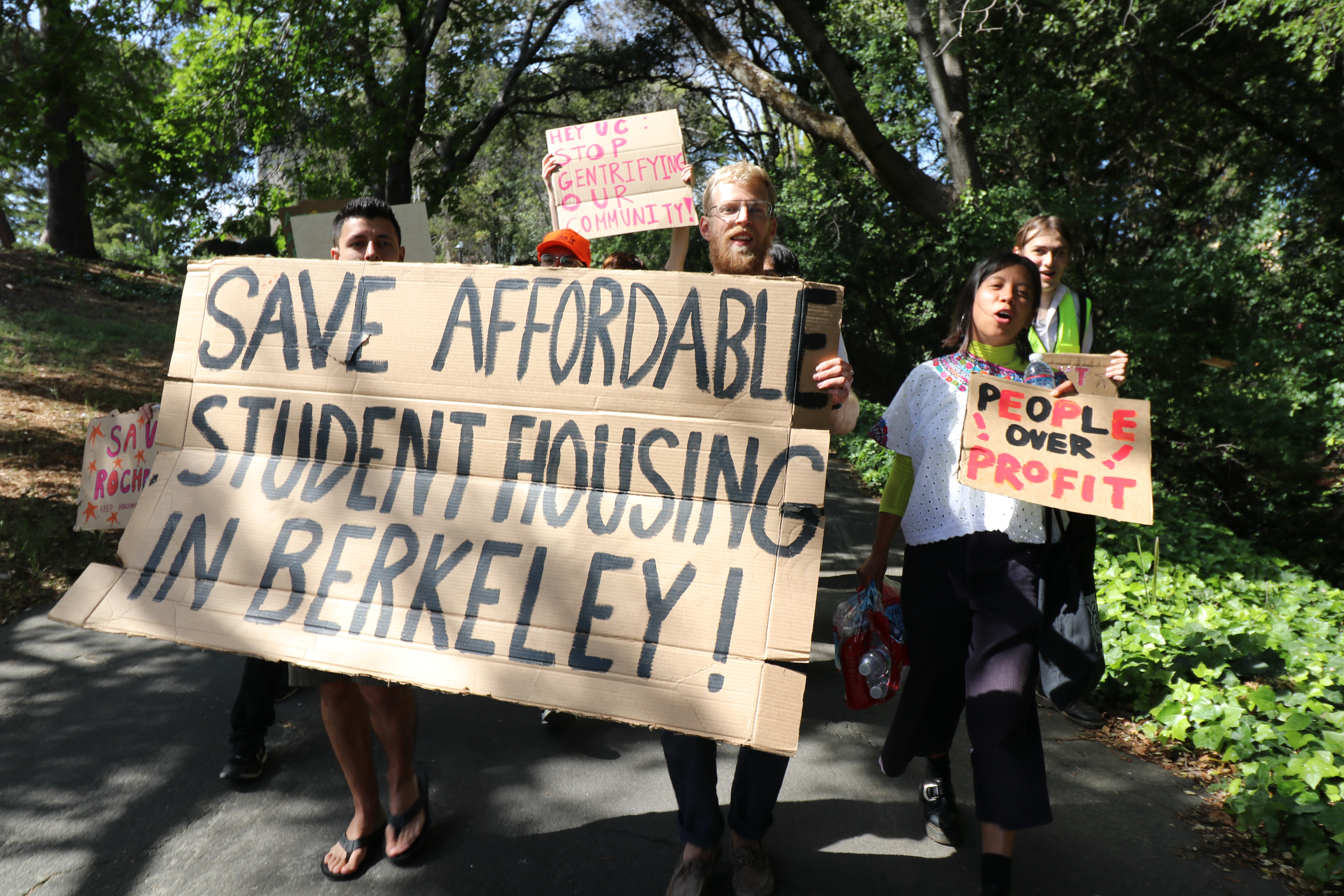 Students marching with signs that read save affordable student housing in Berkeley